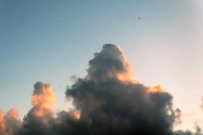 Cloudscape 3 A plane flies over a majestic pillar of cloud at sunset